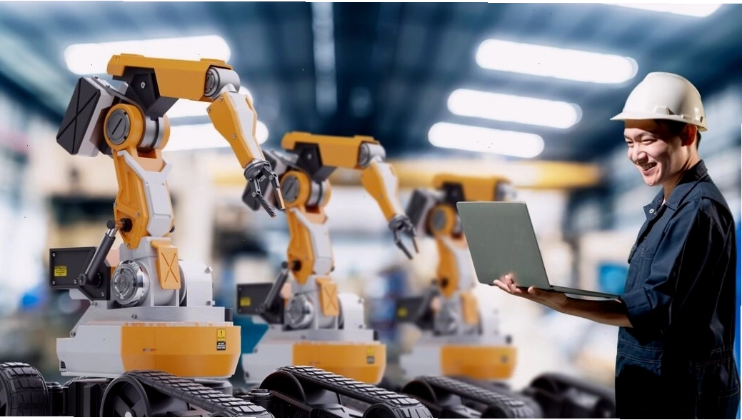 Kỹ sư làm việc với cánh tay robot trong nhà máy sản xuất hiện đại